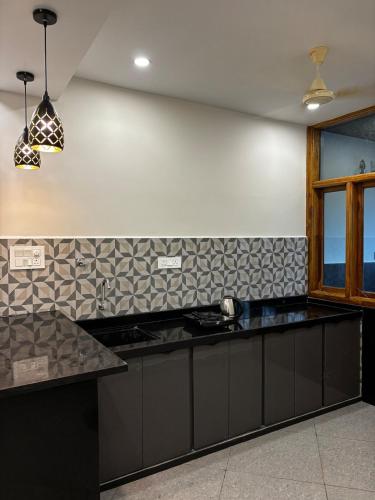 a kitchen with black counter tops and a window at 1Rk Karwar downtown Studio in Kārwār