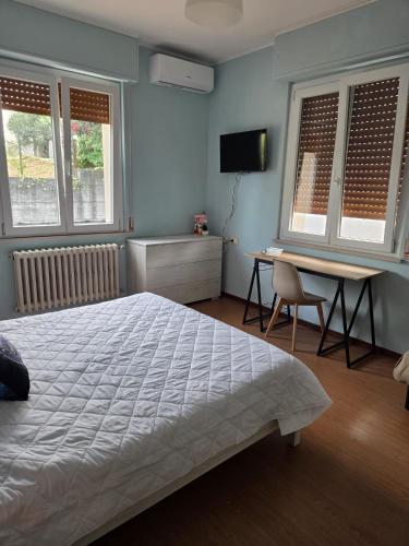 a bedroom with a bed and a desk and two windows at B & B L'Altropianeta in Spoltore