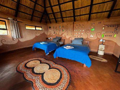 an attic room with two beds and a rug at Marudzi Sunset Lodge in Umtali