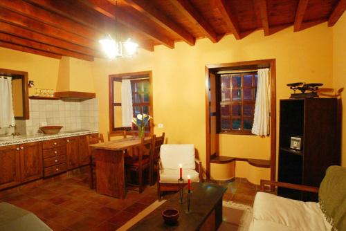a living room with a table and a kitchen at Casa Chamiquela in La Galga