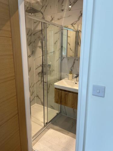 a bathroom with a glass shower and a sink at Northway Apartment's in Oxford