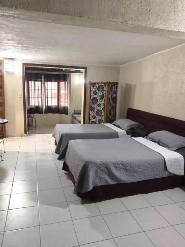 a hotel room with three beds and a window at Mejor relación Precio Comodidad in San Diego