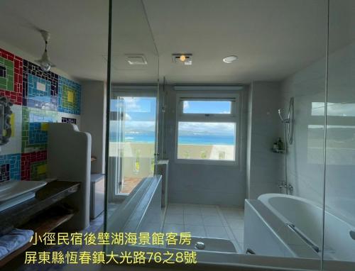 a bathroom with a tub and a sink and a window at Little Path Kenting in Eluan