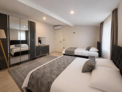 a hotel room with two beds and a mirror at NORA SUİTE in Trabzon