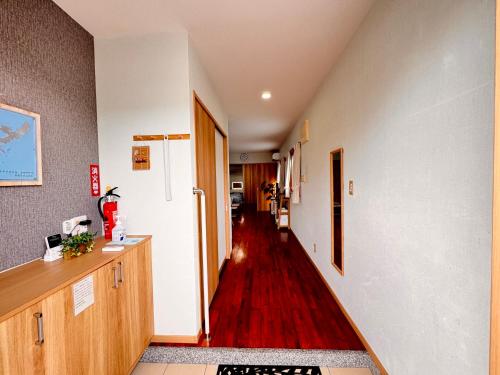 a hallway with a hallway leading to a room at HAMARs ITOMAN HOUSE - ReFaｼｬﾜｰﾍｯﾄﾞ&ﾄﾞﾗｲﾔｰ完備 - 南部観光の拠点 - 1日1組限定 in Itoman