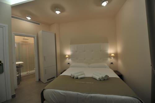 a bedroom with a large bed with two towels on it at Villa Zaccardi in Rome