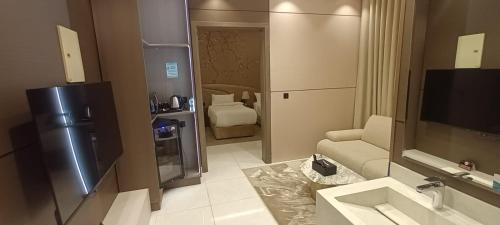 a bathroom with a sink and a living room at Pure Stay House in Taif