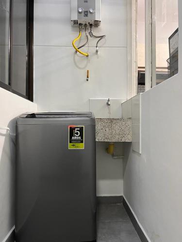 a metal refrigerator in a room with a wall at Apartamento Flor de Manila in Medellín