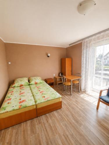 a bedroom with a large bed and a table at Agroturystyka Hogata in Wąchock