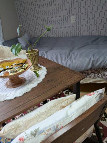 a table with a plate of food on it next to a bed at Kumanokodo KURA in Shingū