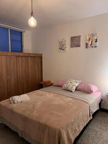 a bedroom with a large bed with two pillows on it at Apartamento Flor de Manila in Medellín