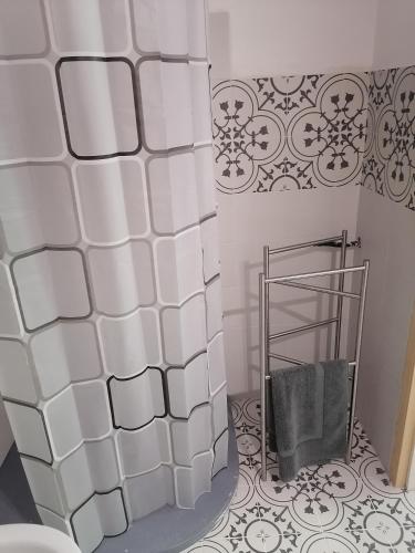 a bathroom with a shower and a white tile wall at La Raccolta in Scheggino