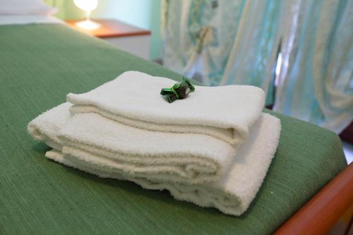 una pila de toallas sentadas encima de una cama en B&B Attico en Catanzaro