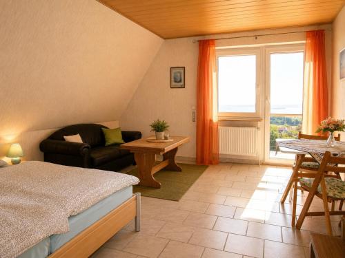 a bedroom with a bed and a couch and a table at Panoramahuis in Sukoró