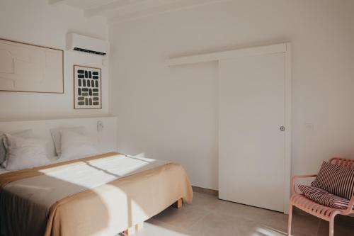 a bedroom with a bed and a chair at La petite villa in Le Gosier