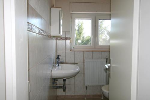 a bathroom with a sink and a toilet and a window at Panoramahuis in Sukoró