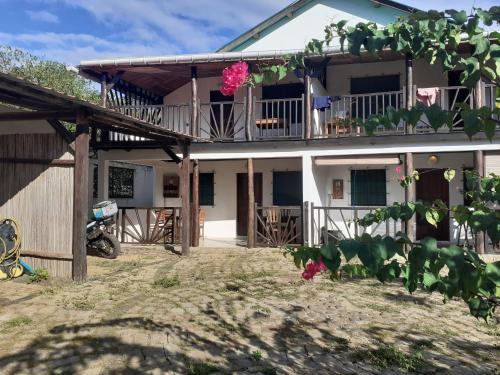 a house with a balcony with pink flowers on it at Villa Armor in Nosy Be