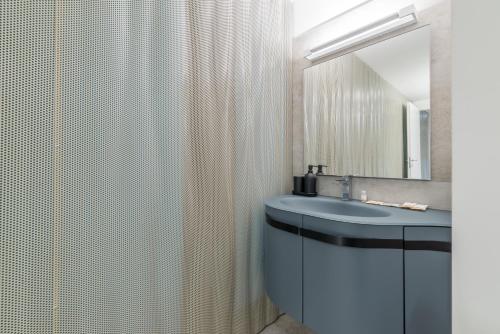a bathroom with a sink and a shower curtain at Effealatapartments - EdenLoft in Senigallia