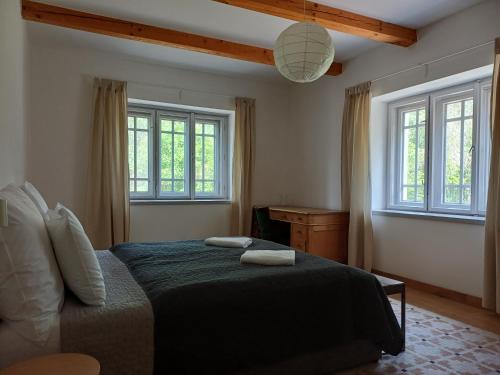 a bedroom with a bed and two windows at Füveskert in Erdőbénye