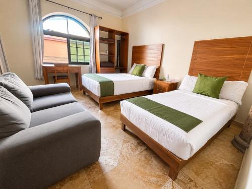 a hotel room with two beds and a couch at Hotel San Jose Centro Historico in San Luis Potosí
