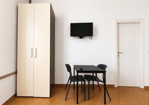 a room with a table and two chairs and a tv at A&D BnB in Porretta Terme