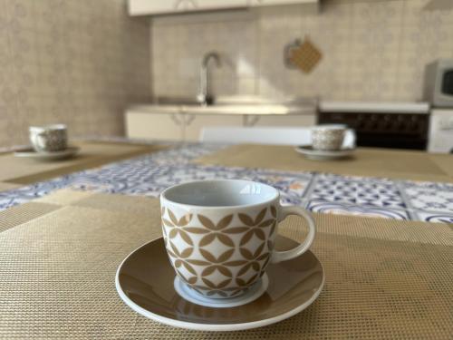 a coffee cup sitting on a plate on a kitchen counter at Casa Maccers in Giardini Naxos