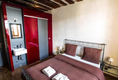 a red bedroom with a bed and a sink at La Grande Maison in Savièse