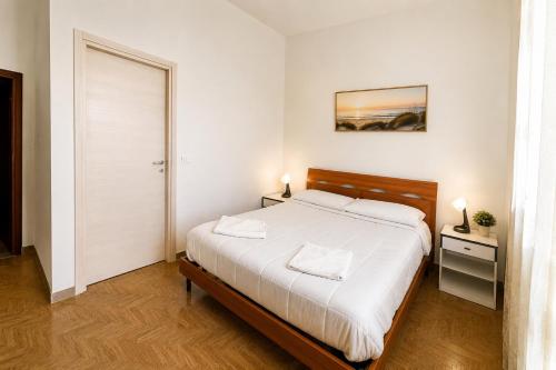 a bedroom with a large bed with white sheets at A&D BnB in Porretta Terme