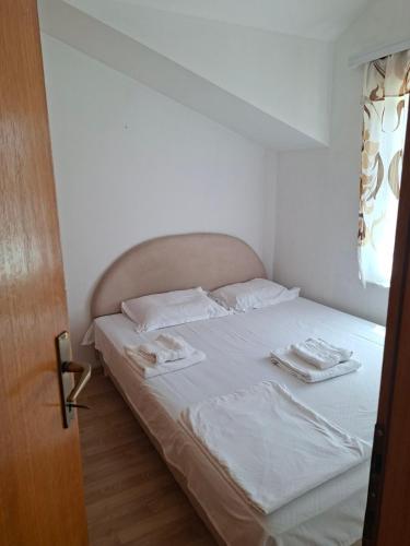 a bedroom with a bed with two towels on it at Apartmani Lazić No 9 in Gracanica