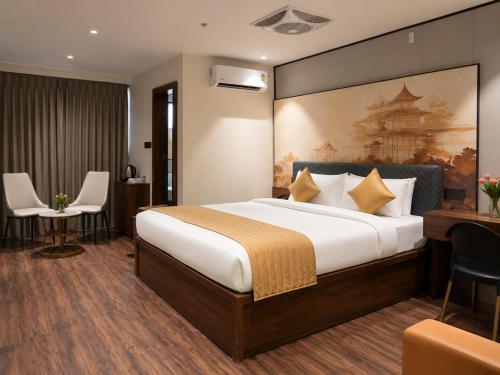 a hotel room with a bed and a desk and chairs at Hotel Elite Executive Lodging in Bārāmati