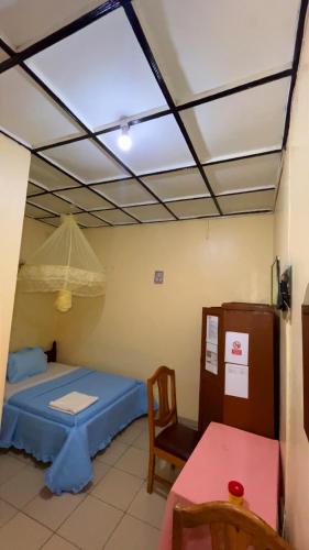 a room with a bed and a table and a window at piece motel in Kigali