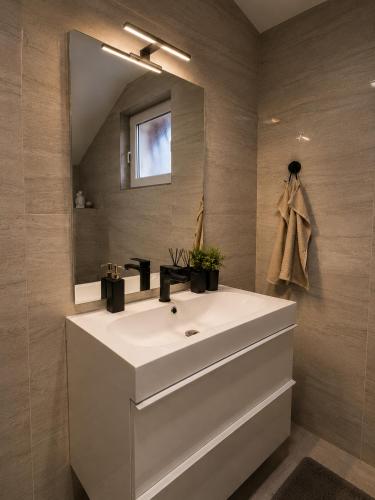 a bathroom with a white sink and a mirror at Villa Zlatan Poolside in Bosanska Gradiška