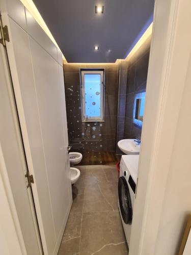 a bathroom with two toilets and a washing machine at Beach House Lleshi in Tale