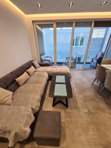a living room with a large couch and a table at Beach House Lleshi in Tale