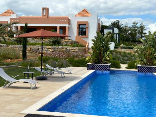 a villa with a swimming pool in front of a house at Patios do Algarve in Ferragudo