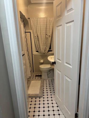 a small bathroom with a toilet and a sink at Logans Lodge in Minneapolis