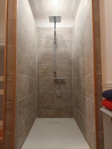 a bathroom with a shower with tiled walls and a light at Le Puy Robin in La Souterraine