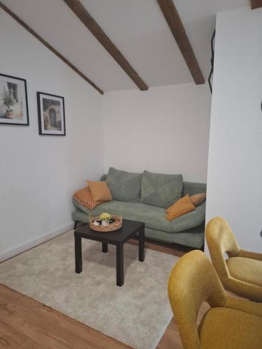 a living room with a couch and a coffee table at Apartman Pojine in Gabonjin