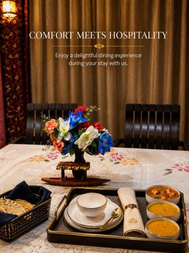 a table with a tray of food and flowers on it at Everest Guest House in Gulmarg