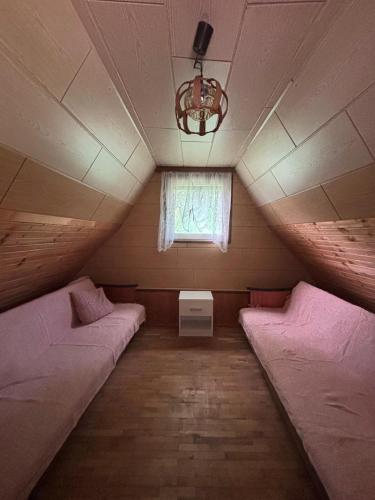 a small room with two beds and a window at Vikendica in Bezdan