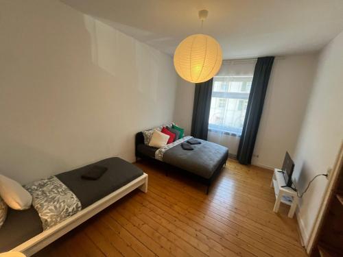 a room with two beds and a table and a lamp at Süße Marie 19 - Coffee for free - in Karlsruhe