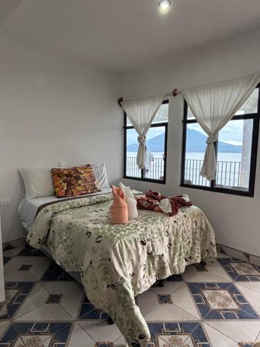 a bedroom with a bed and windows with a bedspread at Casa Miralagos in Santa Cruz La Laguna