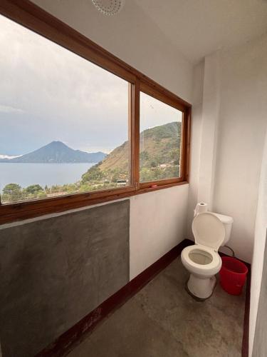 a bathroom with a toilet and a large window at Casa Miralagos in Santa Cruz La Laguna