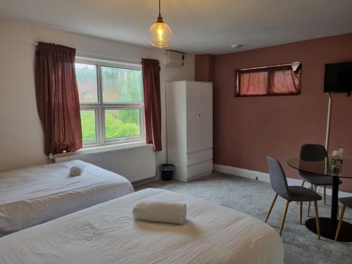 a bedroom with two beds and a table and a chair at Kingfield Boutique Hotel in Sheffield