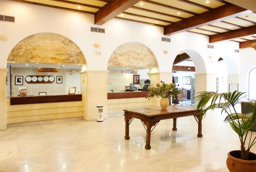 eine Lobby mit einem Tisch in der Mitte eines Gebäudes in der Unterkunft Guadacorte Park in Los Barrios