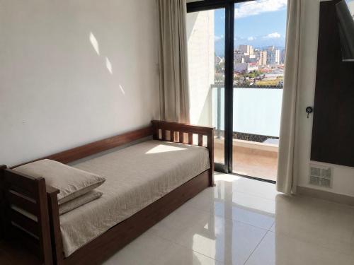a bedroom with a bed and a large window at Descanso Céntrico in Salta