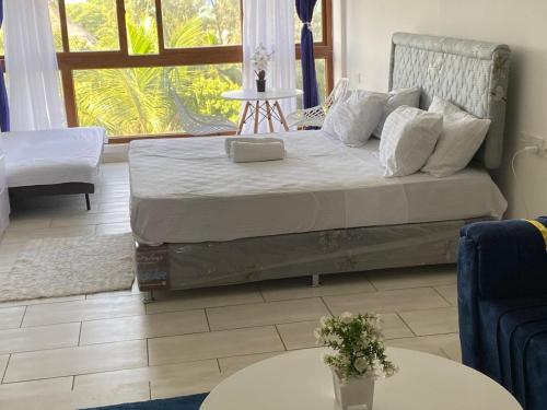 a bed in a room with two tables at Ocean view villa in Diani Beach