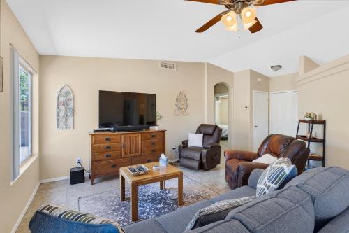 a living room with two couches and a flat screen tv at Peaceful Valley in Tucson