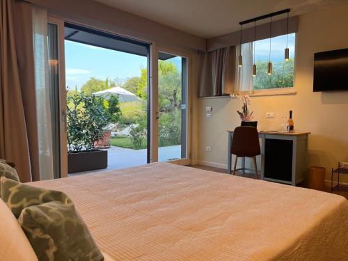 a bedroom with a bed and a sliding glass door at Relais Ca' Morenica in Valeggio sul Mincio