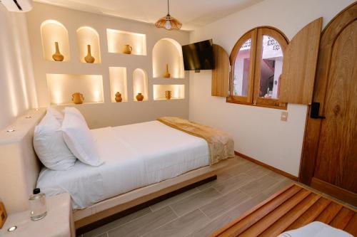 a bedroom with a white bed and a window at Hotel Casa Eteca in San Pedro y San Pablo Etla